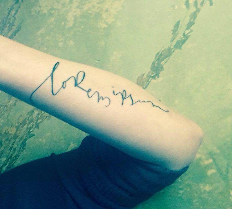 Brazo tatuado con Lorem ipsum