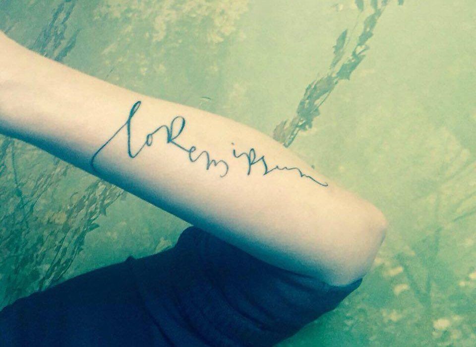 Brazo tatuado con Lorem ipsum